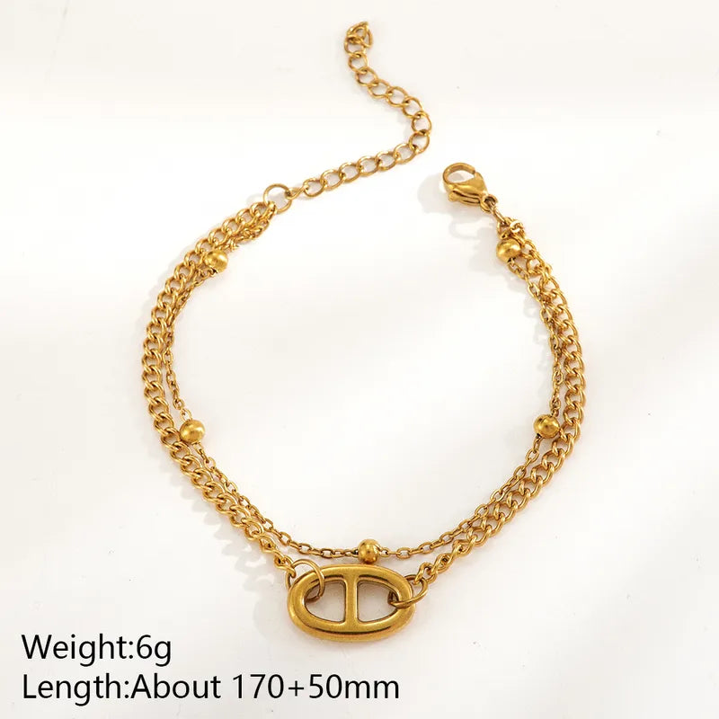Pulsera doble cadena con eslabón central, acero 304 con baño de oro 18k